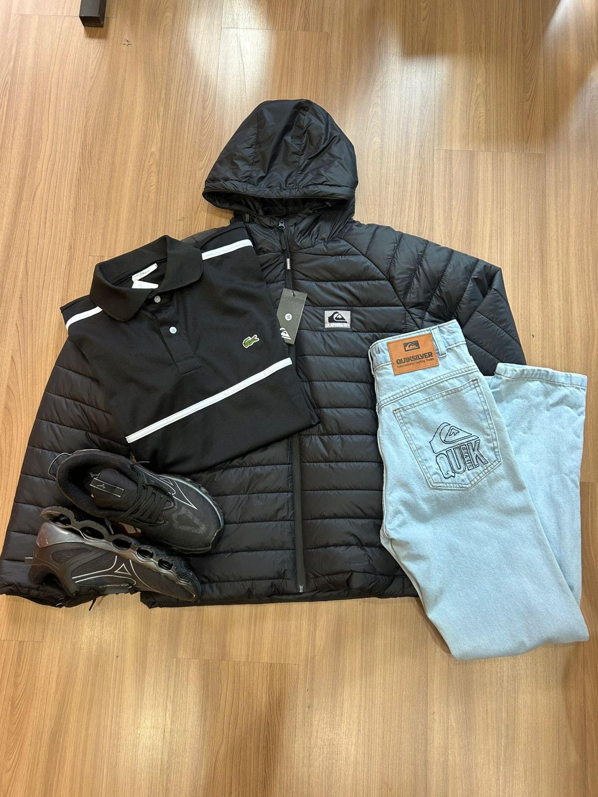 Kit com jaqueta preta, camisa polo, jeans claro e tênis preto