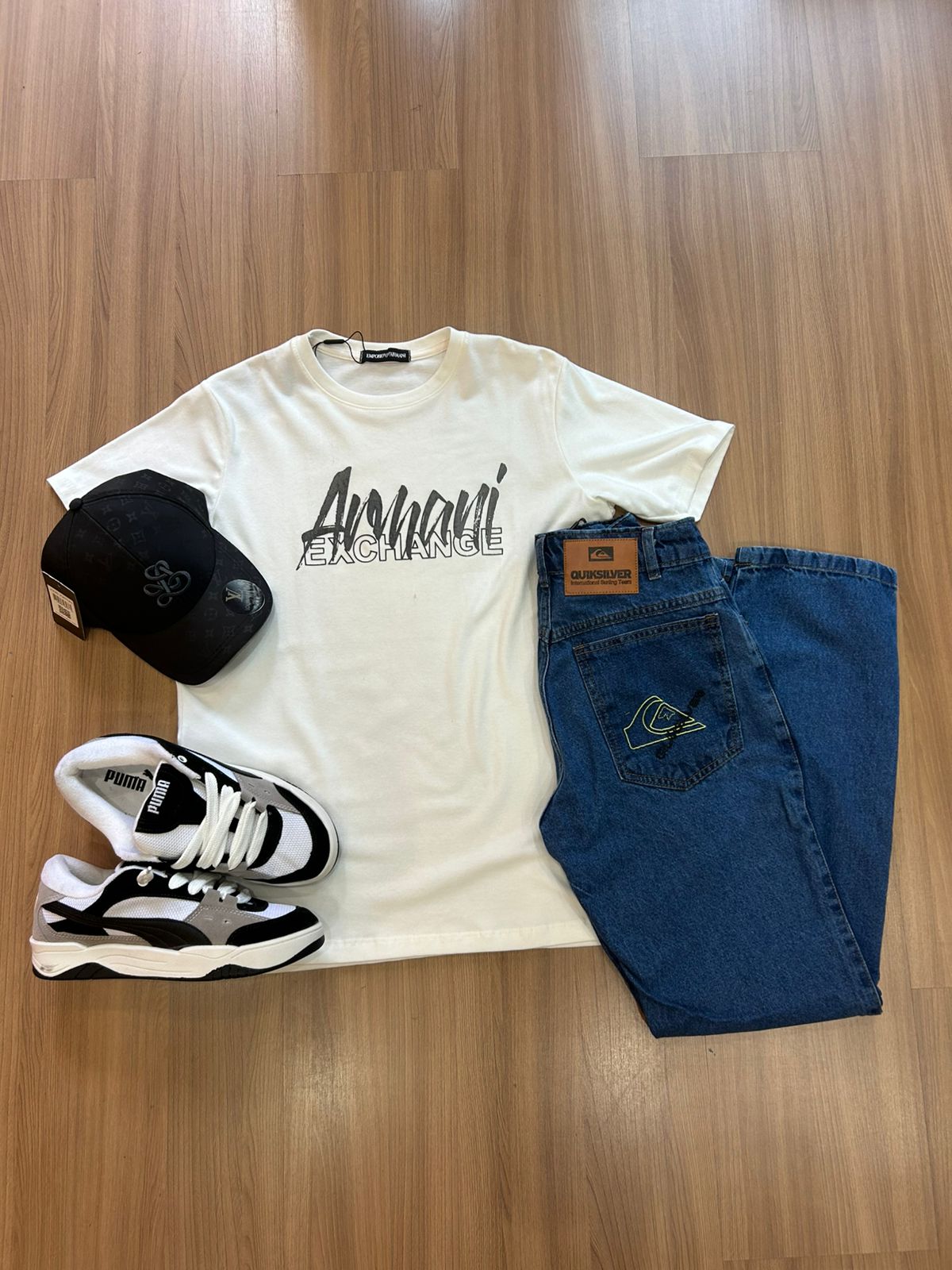 Kit com camiseta branca, jeans azul, boné preto e tênis preto e branco